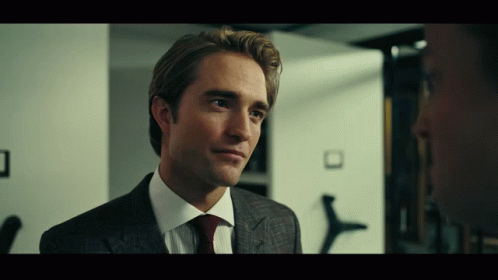 A Man In A Suit And Tie Looks To The Side GIF