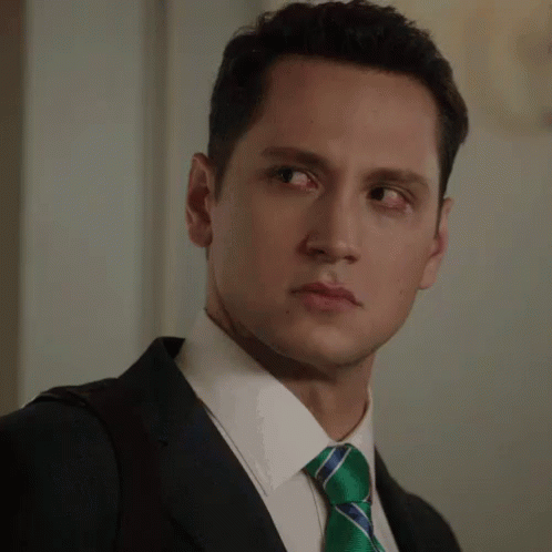 A Man In A Suit And Tie Making A Face GIF