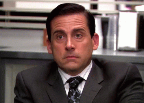 A Man In A Suit And Tie Making A Face GIF