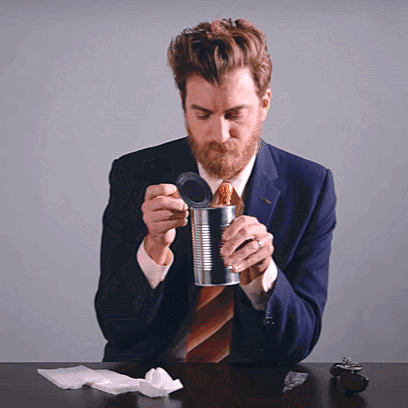 A Man In A Suit And Tie Opens A Can GIF