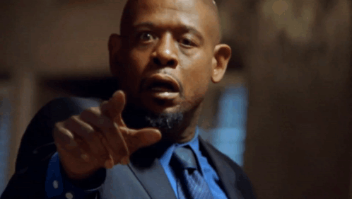 A Man In A Suit And Tie Points His Finger At The Camera GIF