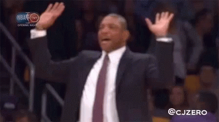 A Man In A Suit And Tie Raising His Arms In The Air GIF