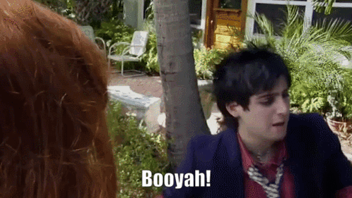 A Man In A Suit And Tie Says Booyah While Standing Next To A Woman GIF