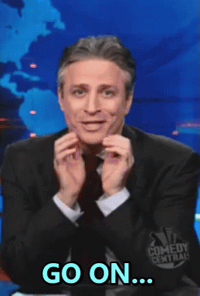 A Man In A Suit And Tie Says Go On In Front Of A Comedy Central Logo GIF