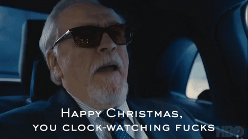 A Man In A Suit And Tie Says Happy Christmas GIF