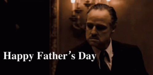 A Man In A Suit And Tie Says Happy Father 'S Day In A Dark Room GIF