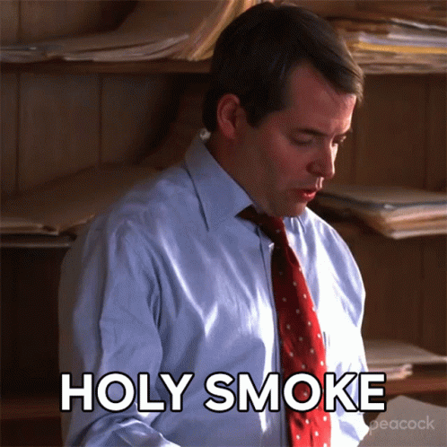 A Man In A Suit And Tie Says Holy Smoke GIF