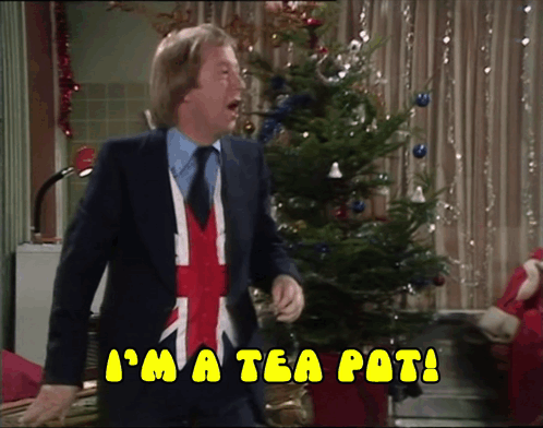 A Man In A Suit And Tie Says I 'M A Tea Pot In Front Of A Christmas Tree GIF