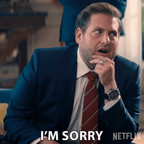 A Man In A Suit And Tie Says I 'M Sorry In A Netflix Ad GIF