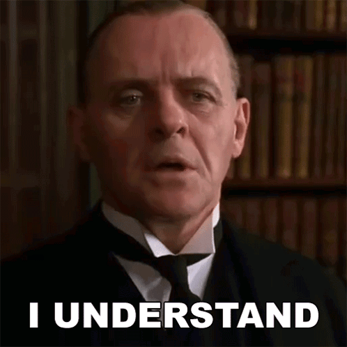 A Man In A Suit And Tie Says I Understand In Front Of A Bookshelf . GIF