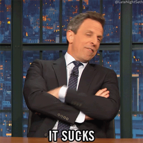 A Man In A Suit And Tie Says " It Sucks " With His Arms Crossed GIF