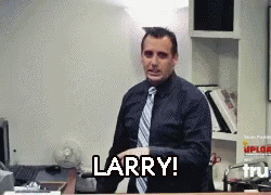 A Man In A Suit And Tie Says Larry In Front Of A Desk GIF