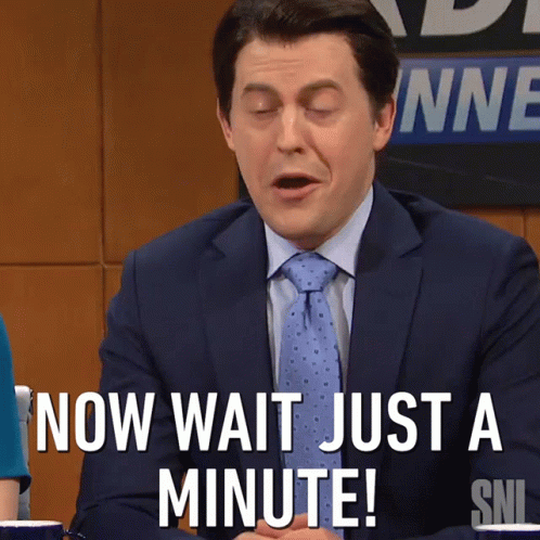 A Man In A Suit And Tie Says " Now Wait Just A Minute ! " GIF