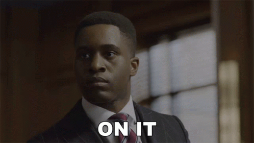 A Man In A Suit And Tie Says " On It " In Front Of A Window GIF
