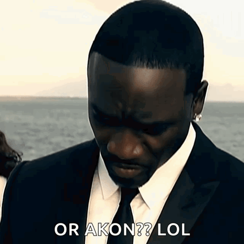 A Man In A Suit And Tie Says Or Akon Lol . GIF