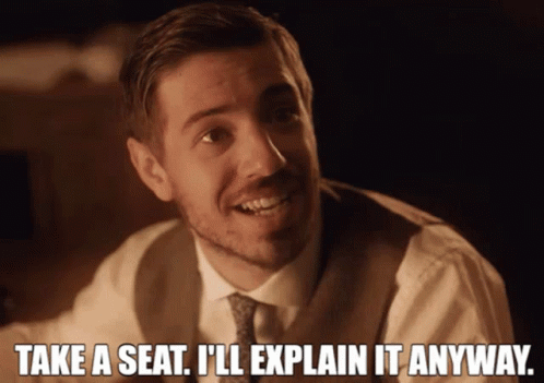 A Man In A Suit And Tie Says Take A Seat GIF