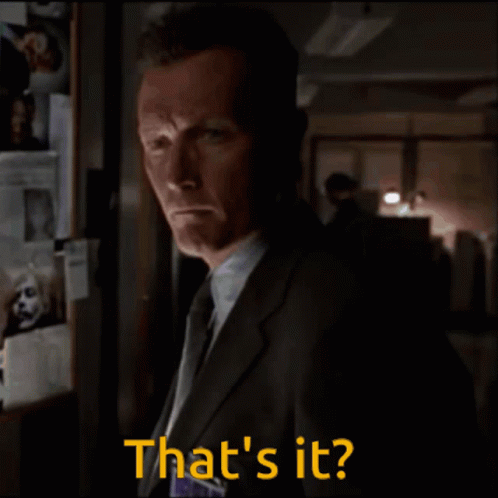 A Man In A Suit And Tie Says That 'S It In A Dark Room GIF