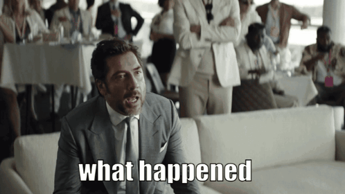 a man in a suit and tie says " what happened " in front of a crowd
