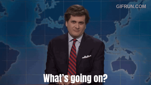 A Man In A Suit And Tie Says What 'S Going On In Front Of A Map GIF