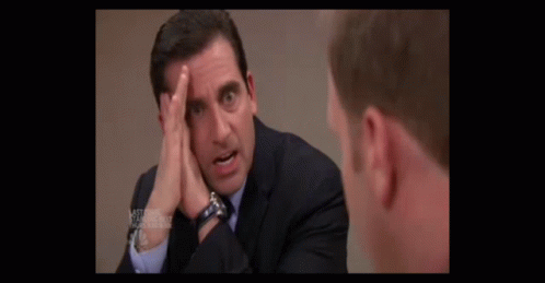 A Man In A Suit And Tie Scratches His Head GIF