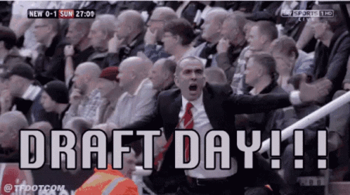A Man In A Suit And Tie Shouts In Front Of A Crowd That Says Draft Day !! GIF