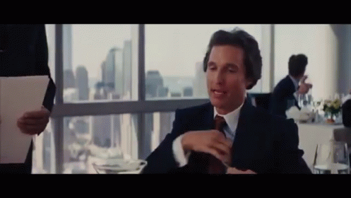 a man in a suit and tie sitting at a table