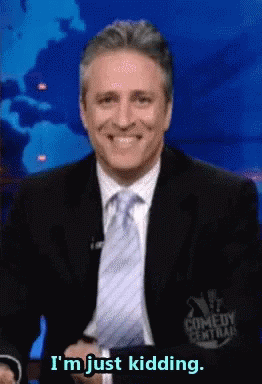 A Man In A Suit And Tie Smiles And Says I 'M Just Kidding GIF