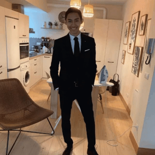 A Man In A Suit And Tie Smiles In A Kitchen GIF
