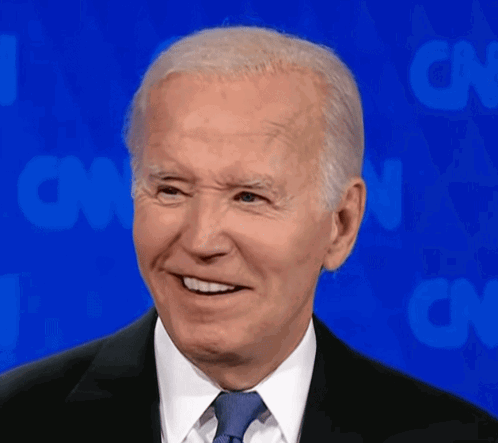 A Man In A Suit And Tie Smiles In Front Of Cnn GIF