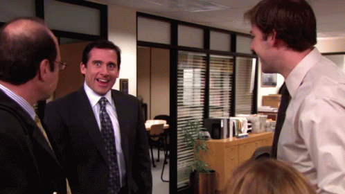 A Man In A Suit And Tie Smiles While Talking To Another Man GIF