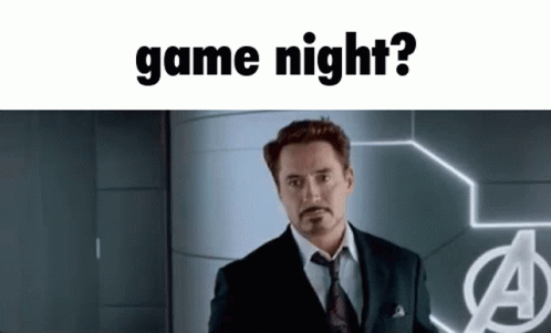 A Man In A Suit And Tie Standing In Front Of A Sign That Says Game Night GIF