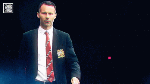 A Man In A Suit And Tie Stands In Front Of A Blue Background That Says Soccer Stories GIF