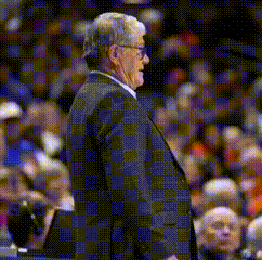 a man in a suit and tie stands in front of a crowd