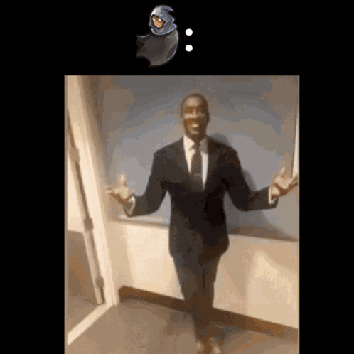 A Man In A Suit And Tie Stands In Front Of A Door GIF