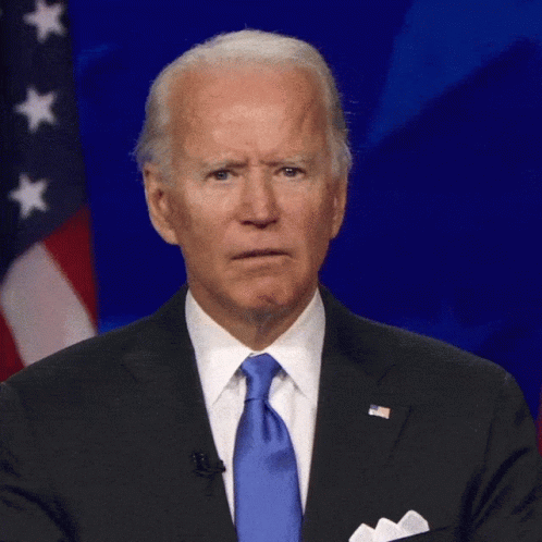 Man In Suit And Tie In Front Of Flag GIF