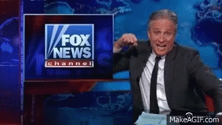 A Man In A Suit And Tie Stands In Front Of A Fox News Channel Sign GIF