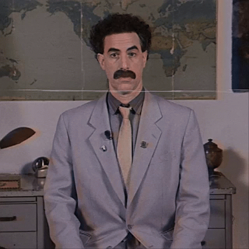A Man In A Suit And Tie Stands In Front Of A Map GIF