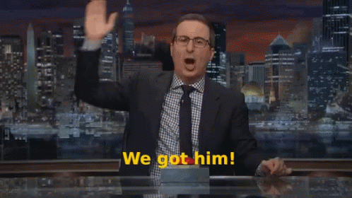 A Man In A Suit And Tie Stands In Front Of A Sign That Says We Come GIF