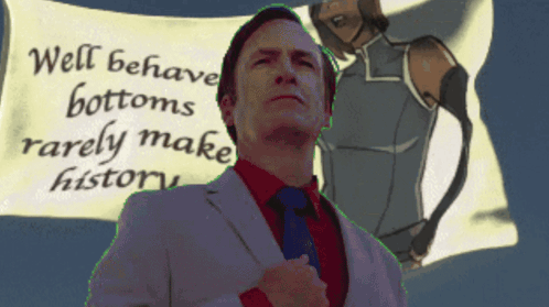A Man In A Suit And Tie Stands In Front Of A Sign That Says " Well Behaved Bottoms Rarely Make History " GIF
