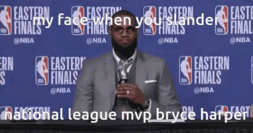 A Man In A Suit And Tie Stands In Front Of A Wall That Says Easter Finals GIF