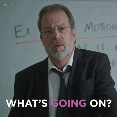 A Man In A Suit And Tie Stands In Front Of A White Board That Says Ex Motion And What 'S Going On GIF