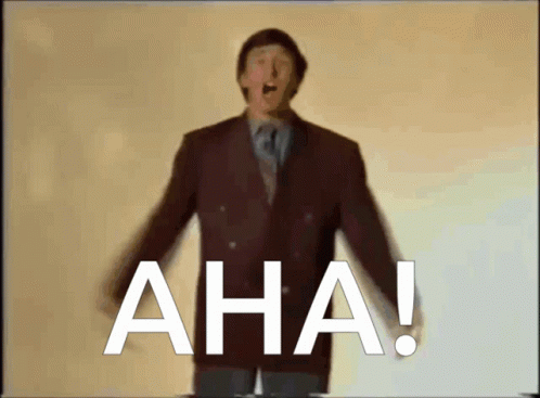 A Man In A Suit And Tie Stands In Front Of The Word Aha GIF