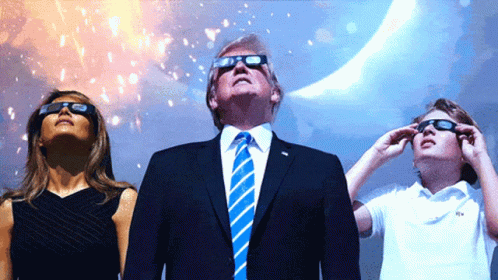 A Man In A Suit And Tie Stands Next To A Woman And A Child Wearing Sunglasses GIF