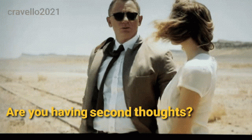 A Man In A Suit And Tie Stands Next To A Woman With The Words " Are You Having Second Thoughts " Above Them GIF