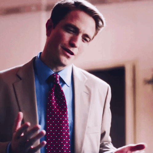 A Man In A Suit And Tie Talking With His Hands Outstretched GIF