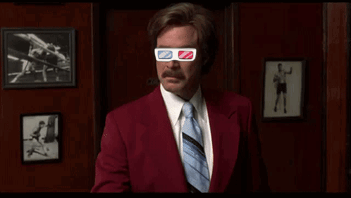 A Man In A Suit And Tie Wearing 3D Glasses GIF