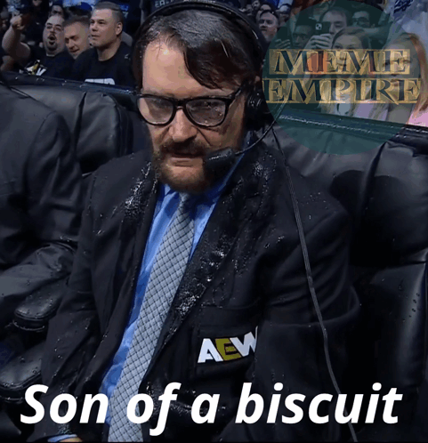 A Man In A Suit And Tie With A Aew Logo On His Jacket GIF