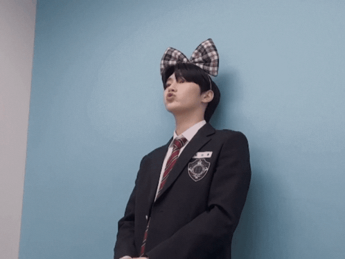 A Man In A Suit And Tie With A Bow On His Head Is Making A Face GIF