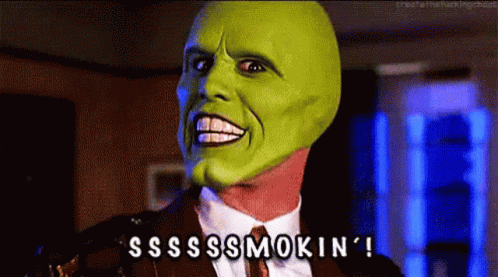 A Man In A Suit And Tie With A Green Mask On His Face GIF