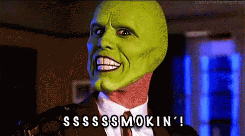 A Man In A Suit And Tie With A Green Mask On His Face Says Sss Smokin ' GIF